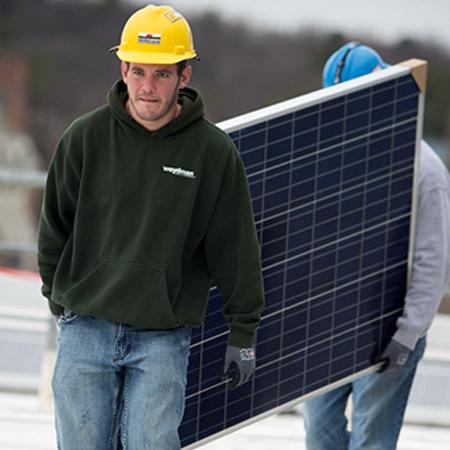 		 Workers walking with a solar panel
	